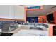 Modern kitchen with white cabinets, blue tile backsplash and stainless steel appliances at 935 S Atlantic Ave # 206, Daytona Beach, FL 32118