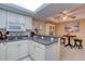 Open kitchen features white cabinets, granite counters, and a breakfast bar at 1 John Anderson Dr # 1070, Ormond Beach, FL 32176
