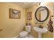 Small bathroom with pedestal sink, toilet and decorative accents at 1 John Anderson Dr # 1070, Ormond Beach, FL 32176
