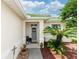 Inviting front entry with gray door, potted plants, and a charming wreath at 399 Foxhill Dr, Debary, FL 32713