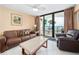 Oceanfront living room with leather furniture and balcony access at 2301 S Atlantic Ave # 306, Daytona Beach Shores, FL 32118