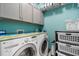 Laundry room with washer, dryer, and storage cabinets at 537 Champion Ridge Dr, Daytona Beach, FL 32124