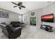 Spacious living room featuring leather furniture, large TV, and ceiling fan at 537 Champion Ridge Dr, Daytona Beach, FL 32124