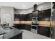 Modern kitchen with dark wood cabinets, granite countertops and stainless steel appliances at 537 Champion Ridge Dr, Daytona Beach, FL 32124