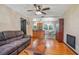 Living room with hardwood floors, a brown leather couch, and a view into the kitchen at 333 Beresford Ave, Deland, FL 32724