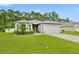 Single story home with gray exterior, two car garage, and landscaped lawn at 370 Sunset Point Dr, Ormond Beach, FL 32174