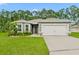 Single story home with gray exterior, two car garage, and landscaped lawn at 370 Sunset Point Dr, Ormond Beach, FL 32174