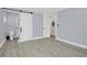 Spacious bedroom with wood-look floors and a barn door leading to the bathroom at 1140 S Orlando Ave # F-16, Maitland, FL 32751