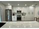 Modern kitchen with white cabinets, stainless steel appliances, and marble countertops at 1140 S Orlando Ave # F-16, Maitland, FL 32751