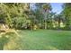 Large backyard with lush green grass and mature trees at 522 Powers Ave, Port Orange, FL 32127