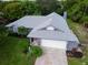 Aerial view of a single-story house with a gray roof and attached garage, nicely landscaped yard at 2704 Collingswood Dr, Deltona, FL 32738