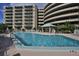 Community pool with lounge chairs and building view at 4 Oceans West Blvd # 407B, Daytona Beach Shores, FL 32118