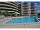 Community pool with surrounding lounge chairs at 4 Oceans West Blvd # 407B, Daytona Beach Shores, FL 32118