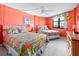 Bedroom with two double beds, orange walls, and colorful bedding at 1415 Ocean Shore Blvd # 303, Ormond Beach, FL 32176