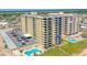 Aerial view of condo building, parking and oceanfront pool at 1415 Ocean Shore Blvd # 303, Ormond Beach, FL 32176
