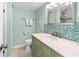 Bathroom with light green walls, a white sink, and a teal mosaic backsplash at 1415 Ocean Shore Blvd # 303, Ormond Beach, FL 32176