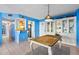 Beachy dining area with a wooden table, white china cabinet, and blue walls at 1415 Ocean Shore Blvd # 303, Ormond Beach, FL 32176