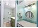 Bathroom features a vanity with a large mirror and teal accents at 1415 Ocean Shore Blvd # 303, Ormond Beach, FL 32176