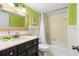 Bathroom with dark brown vanity, a white tub, and lime green walls at 1415 Ocean Shore Blvd # 303, Ormond Beach, FL 32176
