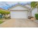 Two-car garage with white door and landscaping at 316 Dahoon Holly Dr, Daytona Beach, FL 32117