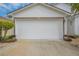 Attached garage with white door and landscaping at 316 Dahoon Holly Dr, Daytona Beach, FL 32117