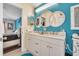 Double vanity bathroom with white cabinets and a teal accent wall at 316 Dahoon Holly Dr, Daytona Beach, FL 32117
