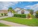 White house with palm trees, green lawn, and a paved driveway at 316 Dahoon Holly Dr, Daytona Beach, FL 32117