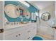 Double vanity bathroom with white cabinets and a teal accent wall at 316 Dahoon Holly Dr, Daytona Beach, FL 32117