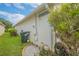 Side of the house with landscaping, a green waste bin, and decorative pots at 316 Dahoon Holly Dr, Daytona Beach, FL 32117