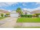 Front view of a house with a white exterior, green lawn, and a two-car garage at 316 Dahoon Holly Dr, Daytona Beach, FL 32117