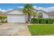 Single-story home with white garage door and palm tree at 316 Dahoon Holly Dr, Daytona Beach, FL 32117