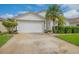 House exterior featuring a white garage door and landscaping at 316 Dahoon Holly Dr, Daytona Beach, FL 32117