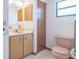 Clean bathroom with pink vanity, toilet, and a mirror at 10170 Sw 96Th Ct, Ocala, FL 34481