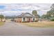 Brick community building with landscaping and a paved driveway at 10170 Sw 96Th Ct, Ocala, FL 34481