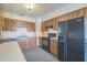 Wood kitchen cabinets, black appliances, and floral wallpaper at 10170 Sw 96Th Ct, Ocala, FL 34481