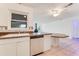 Kitchen with stainless steel dishwasher and view into adjacent living area at 660 Saxon Blvd, Deltona, FL 32725