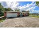 Home's exterior features a white garage door and spacious driveway at 660 Saxon Blvd, Deltona, FL 32725