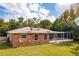 Brick house exterior with screened patio and grassy yard at 660 Saxon Blvd, Deltona, FL 32725
