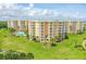 Aerial view of condo building with pool and lush landscaping at 4650 Links Village Dr # C303, Ponce Inlet, FL 32127