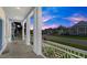 Covered porch with white columns, stone flooring, and a view of the neighborhood at 53 Marden Dr, Ormond Beach, FL 32176