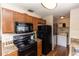 Galley kitchen, black appliances, wood cabinets at 1230 8Th Ave, Deland, FL 32724