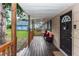 Wooden front porch with red chairs and a black door at 1230 8Th Ave, Deland, FL 32724