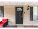 Black front door with a red chair on the porch at 1230 8Th Ave, Deland, FL 32724