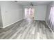 Spacious living room featuring gray vinyl plank flooring and updated finishes at 201 N Hill Ave # 150, Deland, FL 32724