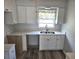 Renovated kitchen boasts white cabinets, quartz countertops, and stainless steel sink at 201 N Hill Ave # 150, Deland, FL 32724