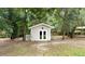 Small storage shed in the backyard, surrounded by trees at 5711 John Anderson Hwy, Flagler Beach, FL 32136