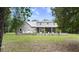 Home's back elevation showcasing a screened porch and fenced yard at 5711 John Anderson Hwy, Flagler Beach, FL 32136