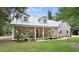 Two-story house with a metal roof, large front porch, and mature landscaping at 5711 John Anderson Hwy, Flagler Beach, FL 32136