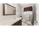 Clean bathroom with dark vanity and decorative mirror at 5711 John Anderson Hwy, Flagler Beach, FL 32136