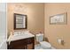 Clean bathroom with dark vanity, a toilet, and framed art at 5711 John Anderson Hwy, Flagler Beach, FL 32136